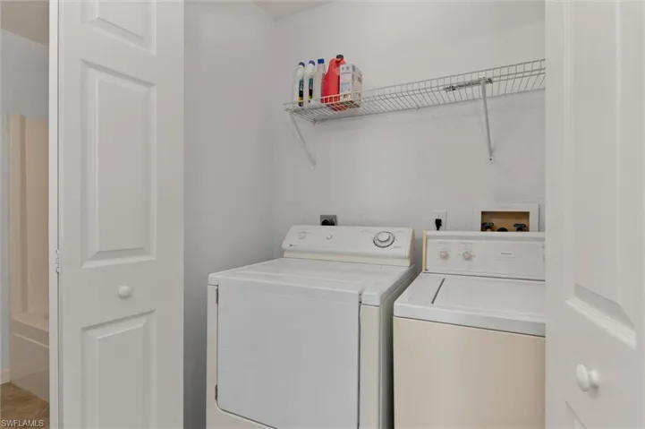 Dedicated laundry area featuring a wire shelving unit and bi-fold doors