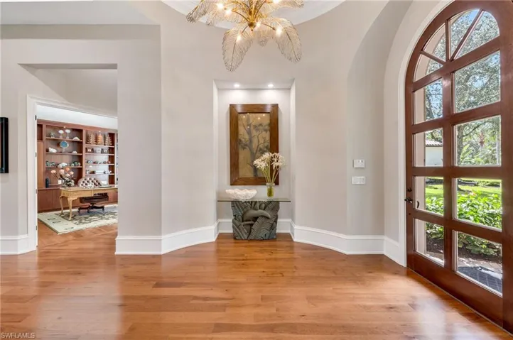 Beautiful mahogany doors with beveled, impact glass serve as the entry to this beautiful residence.  To the left is a large office and luxurious guest powder room.