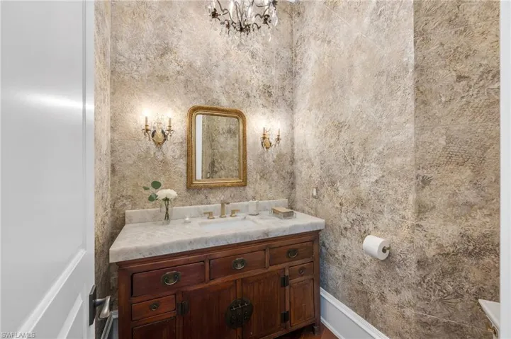 The guest Powder Bath is inviting with one-of-a-kind vanity, thick quartzite top, Brizo, polished gold fixture, Kohler products, and a refined, sumptuous feel for a Powder room....