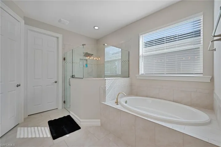 Bathroom featuring a shower stall, a garden tub, tile patterned floors, and recessed lighting