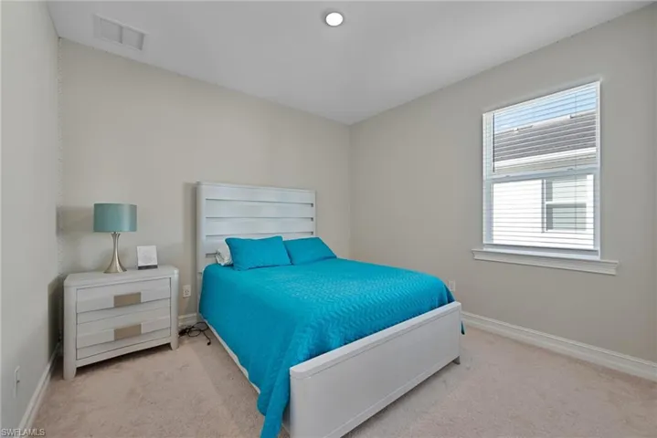 Bedroom with baseboards and light carpet