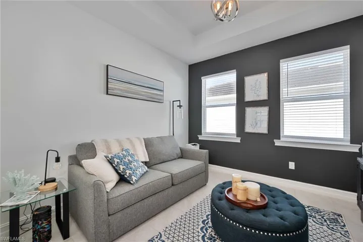 Tiled living room with baseboards and a chandelier