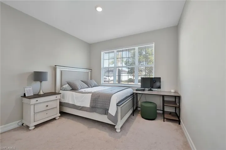 Bedroom featuring light carpet, recessed lighting, and a desk