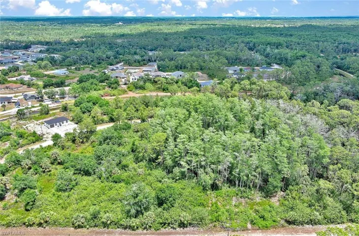 Aerial view of property and surrounding area featuring a heavily wooded area