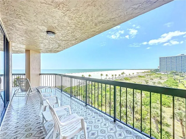 Balcony featuring a view of the beach and a water view