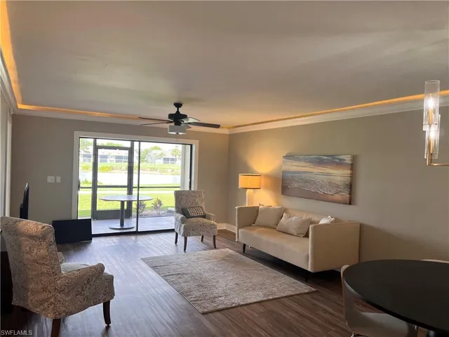 Living area with ornamental molding, luxury vinyl tile floors, a water view, and ceiling fan