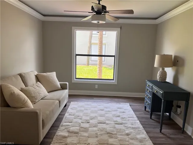 Den/bedroom with crown molding, luxury vinyl tile flooring, and a ceiling fan
