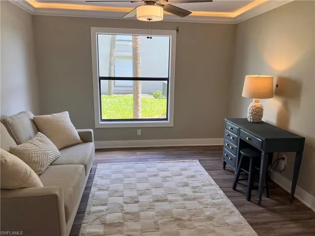Den/bedroom with crown molding, luxury vinyl tile floors, and ceiling fan