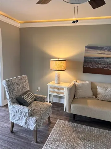 Living room with ornamental molding, ceiling fan, and luxury vinyl tile floors