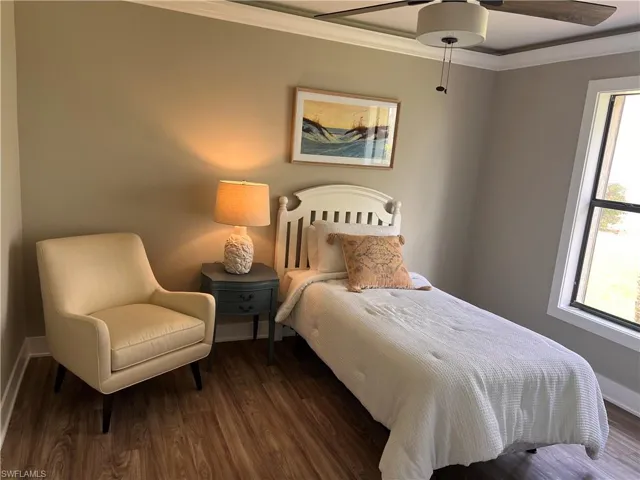 Bedroom 2 featuring ornamental molding, wood finished floors, and ceiling fan