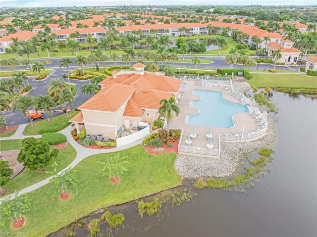 Drone / aerial view of a pool area and a nearby body of water