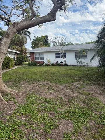 View of front of house with a front lawn and stucco siding