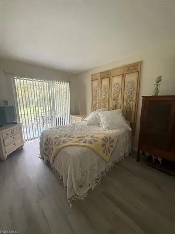 Bedroom 1 featuring access to outside and wood finished floors