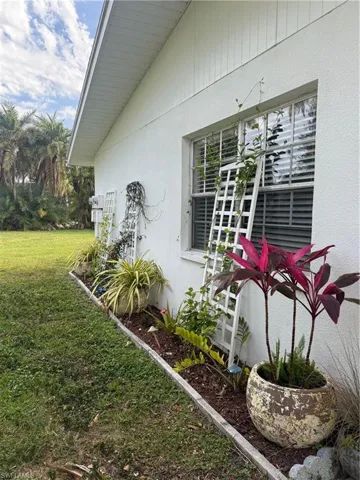 View of side of property with a yard and stucco siding