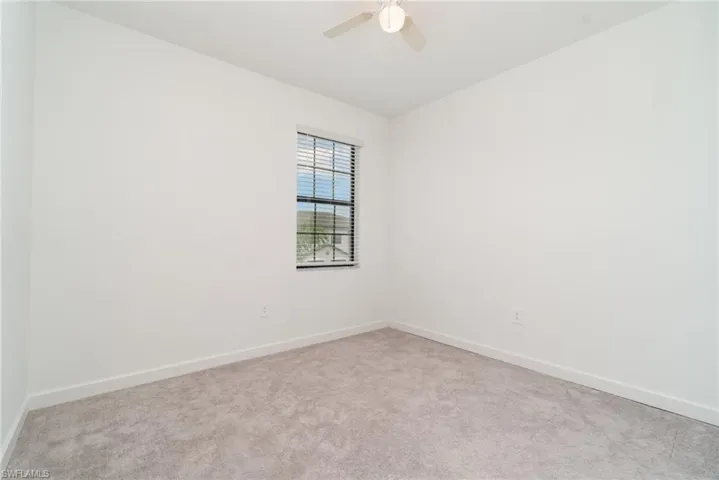 Carpeted empty room with baseboards