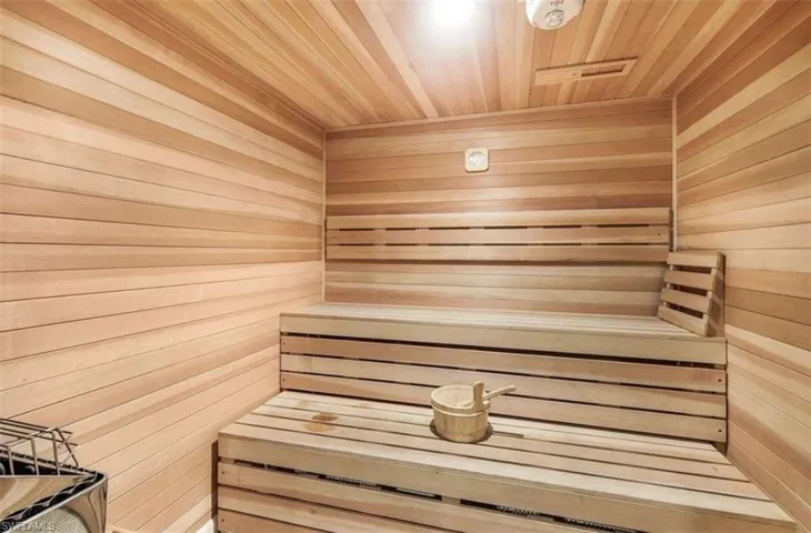 Relaxing sauna featuring wooden ceiling and wooden walls