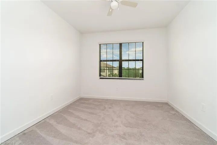 Empty room with light carpet and ceiling fan