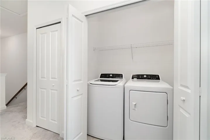 Laundry room featuring independent washer and dryer and light carpet