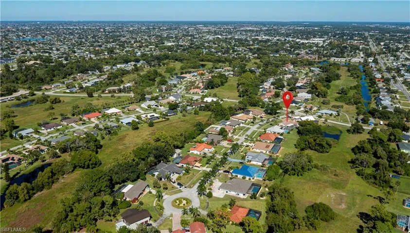 Aerial view of property and surrounding area featuring nearby suburban area