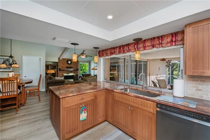 Kitchen LG dish washer, decorative light fixtures, pass through window, healthy amount of natural light, and open floor plan