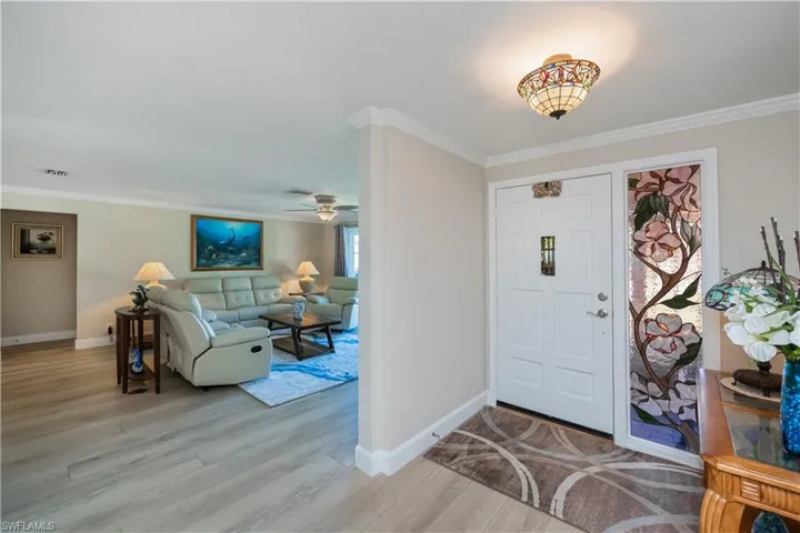 Entrance foyer with crown molding, ceiling fan, and new vinyl plank flooring throughout