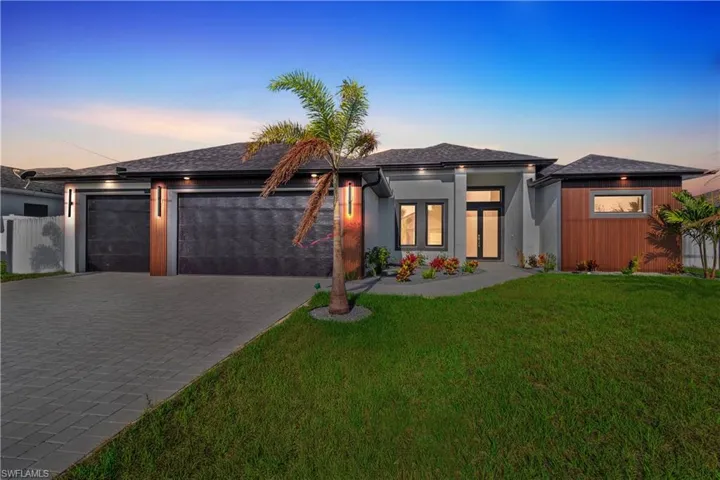 Prairie-style house with a front lawn, driveway, and a garage