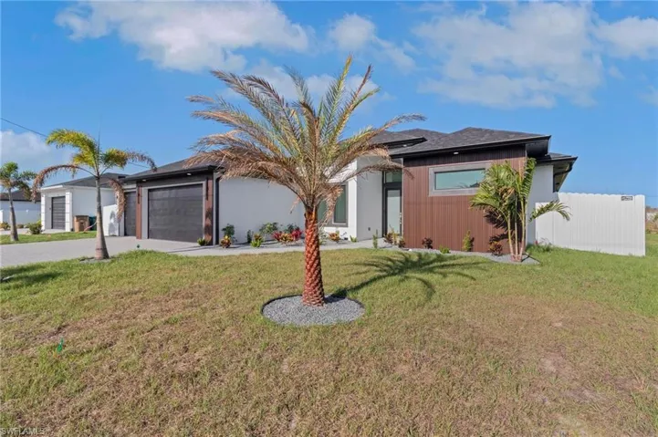 Ranch-style house with decorative driveway, a front lawn, and a garage