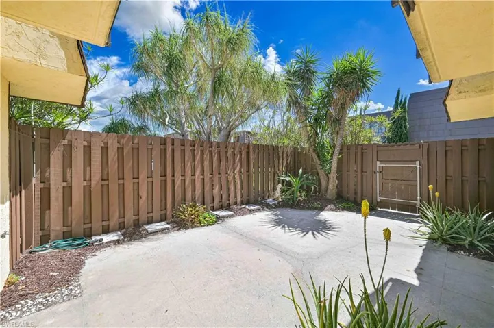 Fenced backyard featuring a patio area and a gate