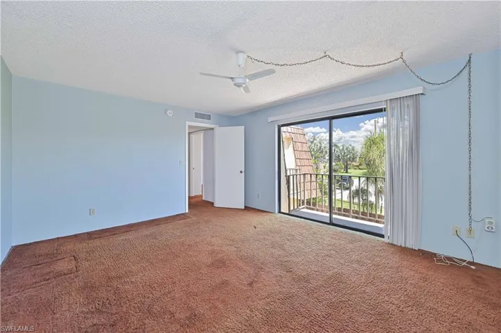 Unfurnished room with a ceiling fan, carpet flooring, and a textured ceiling