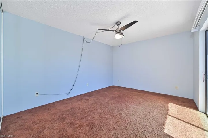 Spare room featuring carpet floors, a textured ceiling, and ceiling fan