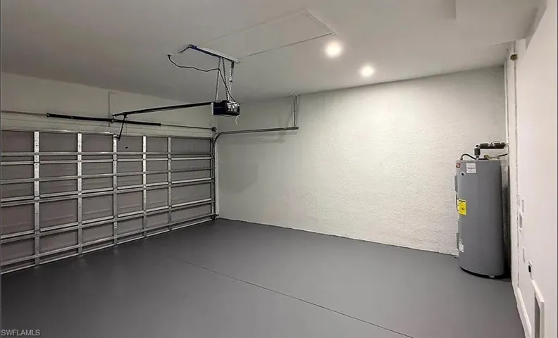 Garage with electric water heater and a textured wall