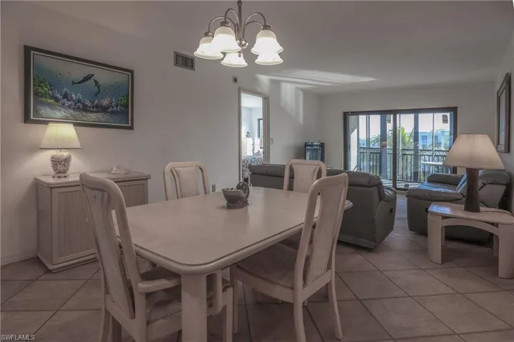 Dining area with light tile patterned floors and a chandelier