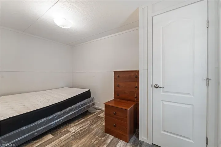 Bedroom featuring dark wood finished floors and a textured ceiling