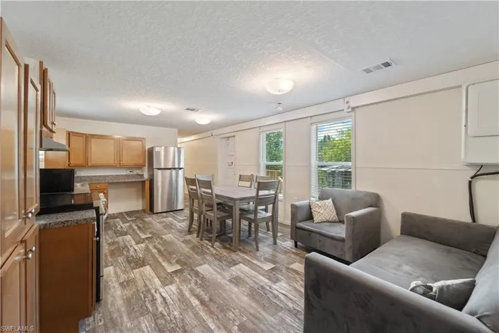 Living area featuring estacked washer and dryer, wood finished floors, and a textured ceiling