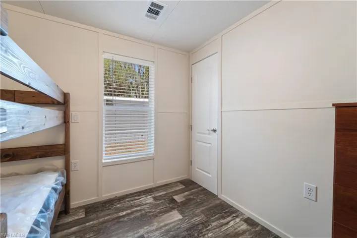 Unfurnished bedroom with dark wood-style flooring