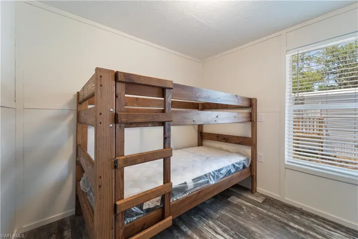 Bedroom featuring wood finished floors, a textured ceiling, and baseboards