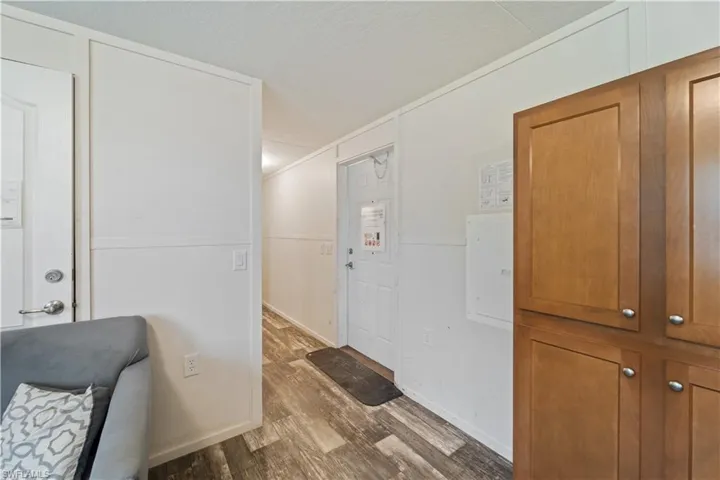 Hall featuring wood finished floors, a textured ceiling, and electric panel