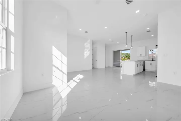 Unfurnished living room with light marble finish flooring and recessed lighting