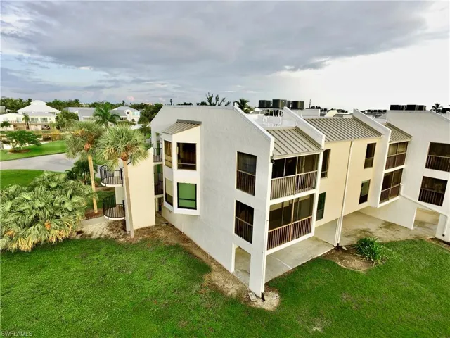 Rear view of property with a balcony and a yard