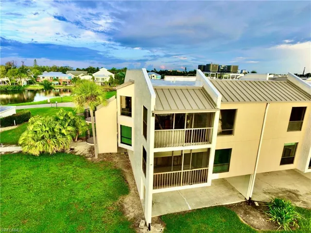 Back of property with a water view and a yard