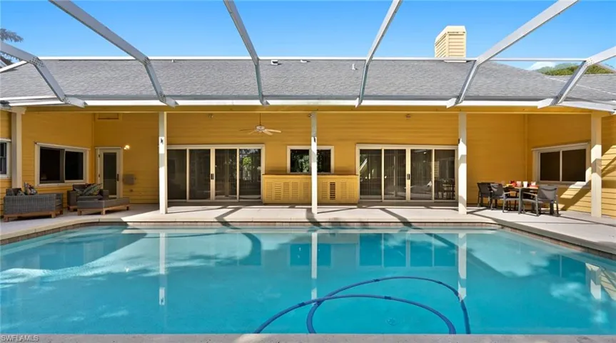 Rear view of house with a sunroom, a shingled roof, glass enclosure, and ceiling fan