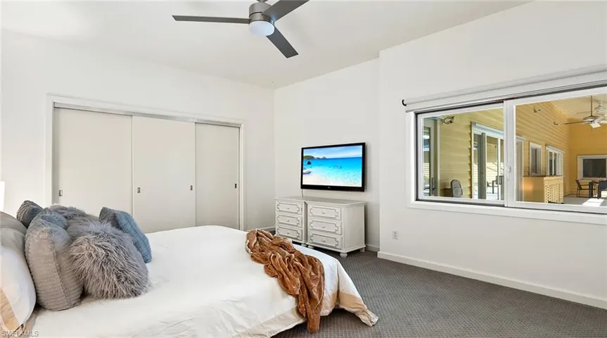 Carpeted bedroom with a closet and a ceiling fan