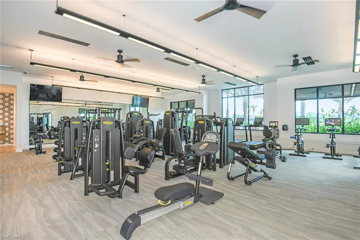 Workout area with ceiling fan and light colored carpet