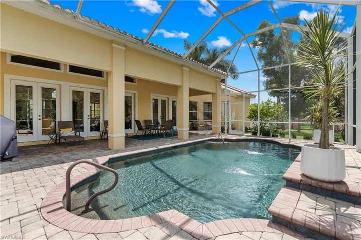 Swimming pool with a patio and glass enclosure