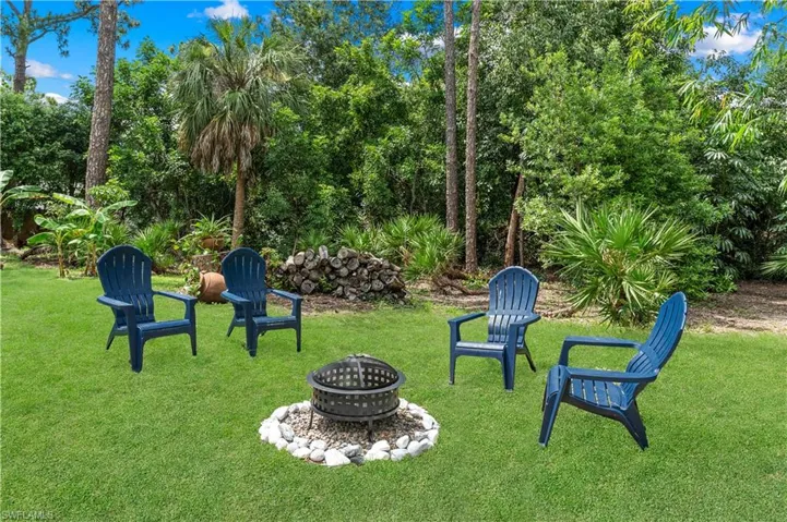View of grassy yard featuring a fire pit