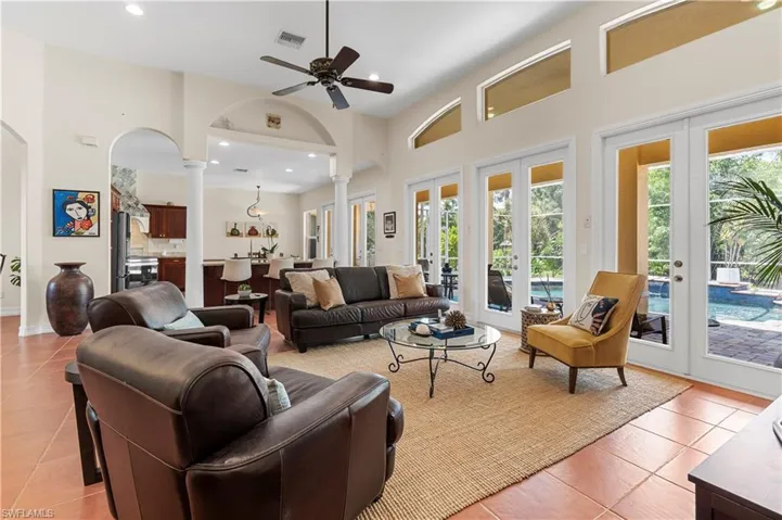 Living room with french doors, light tile patterned floors, a ceiling fan, recessed lighting, and arched walkways