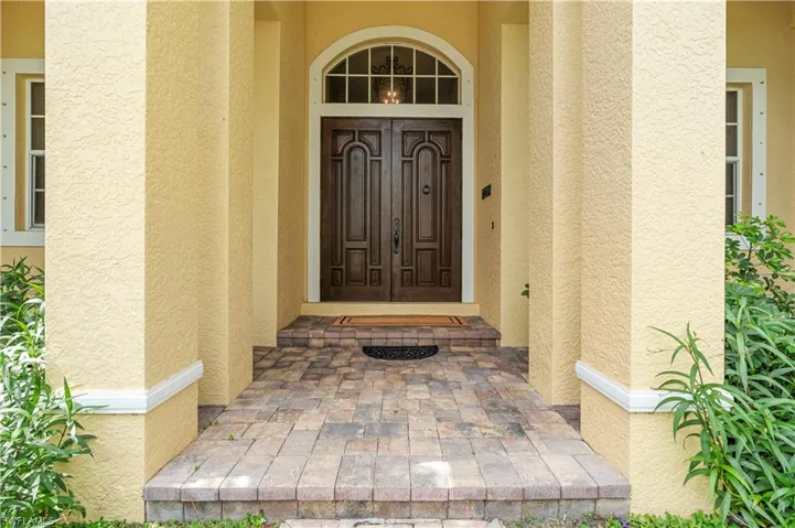 Mediterranean / spanish-style home with decorative driveway, a front lawn, stucco siding, a tiled roof, and a garage