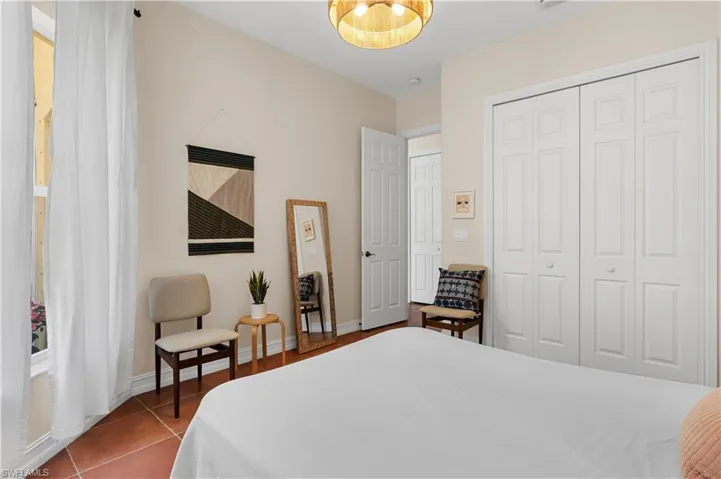 Hall featuring dark tile patterned flooring and baseboards