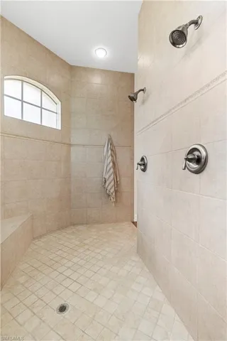 Bathroom featuring tiled shower and healthy amount of natural light