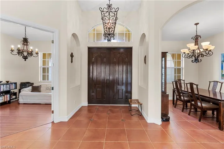 Tiled dining space featuring a chandelier and baseboards
